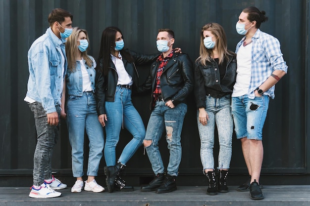 New normal and rules. Group of friends wearing prevention masks during their meeting outdoors.