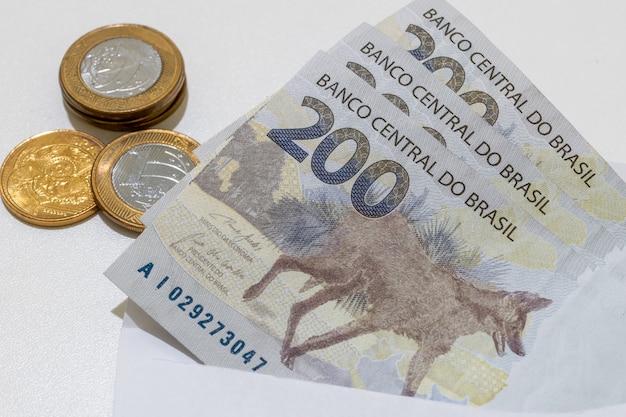 Photo new notes and coins of brazilian money with the image of the maned wolf.