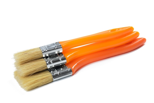 Photo new paint brush with orange handle isolated on white background