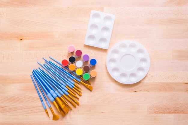 New paint supplies on a wood table.