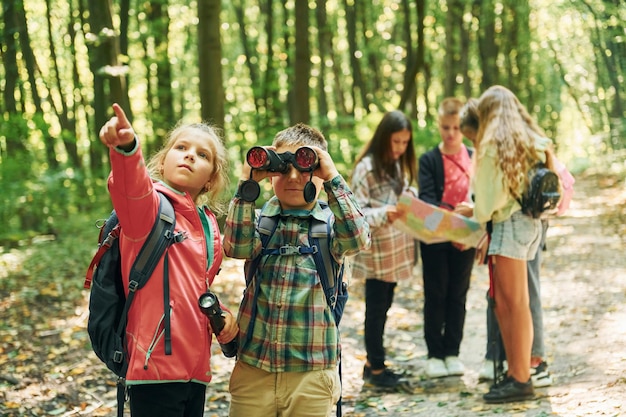 Photo new places kids in green forest at summer daytime together