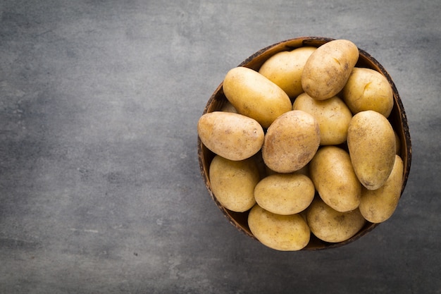 New potato on the bowl, gray background.