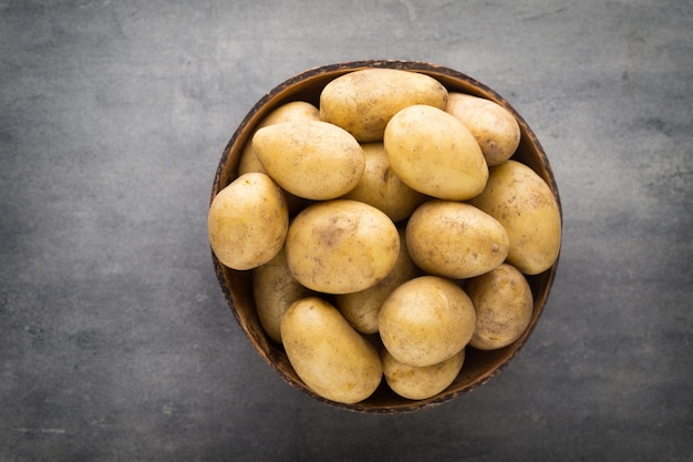 New potato on the bowl, gray background.