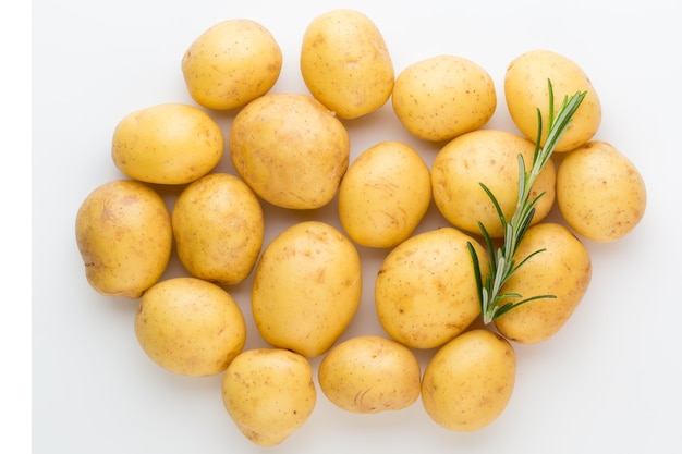 New potato and rosemarin isolated on white surface close up.