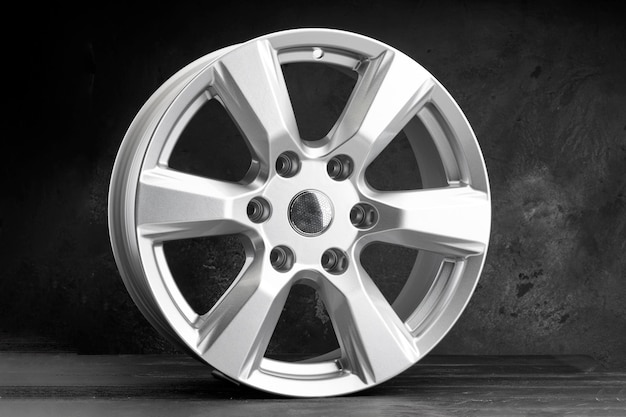 A new powerful sixspoke alloy wheel in silver color on a dark textured background auto parts for SUVs and crossovers