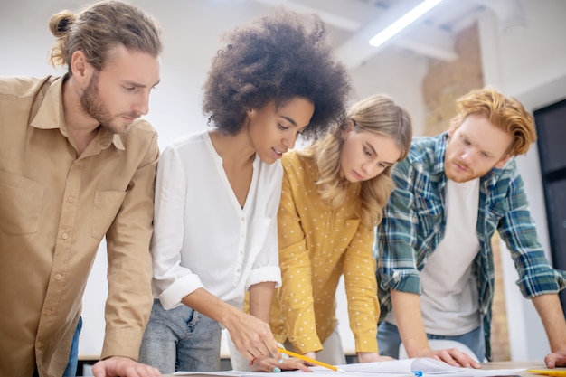 Nuovo progetto. gruppo di giovani professionisti che lavorano insieme al progetto e che guardano concentrati