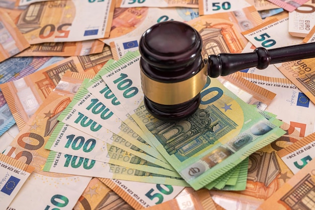 New pure euro banknotes are laid out and on them a powerful wooden judge's gavel