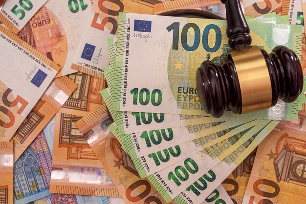 New pure green and orange euro banknotes are laid out with a powerful wooden judge's gavel on them. Money concept. Business concept. Wealth concept