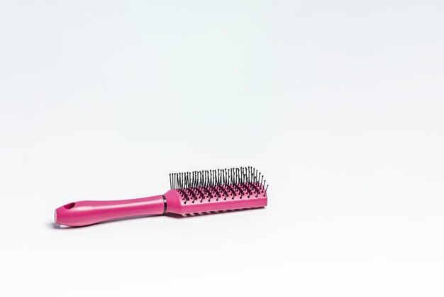 Photo new purple hairbrush with black bristles on a white bathroom cabinet