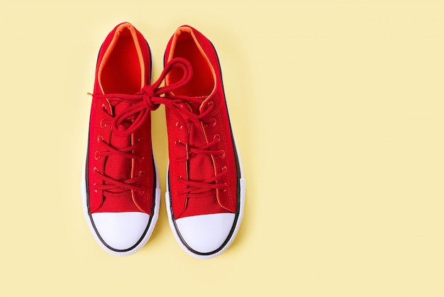 New red sneakers on yellow with copy space.