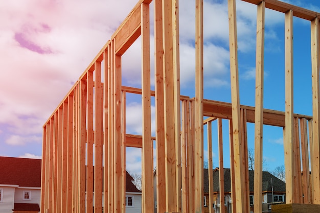 New residential construction home framing against a blue sky.