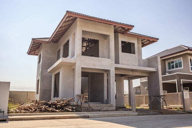Photo new residential house contemporary style building in progress at construction site with blue sky