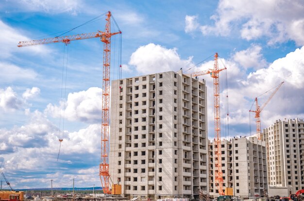 Photo new residential houses and industrial cranes