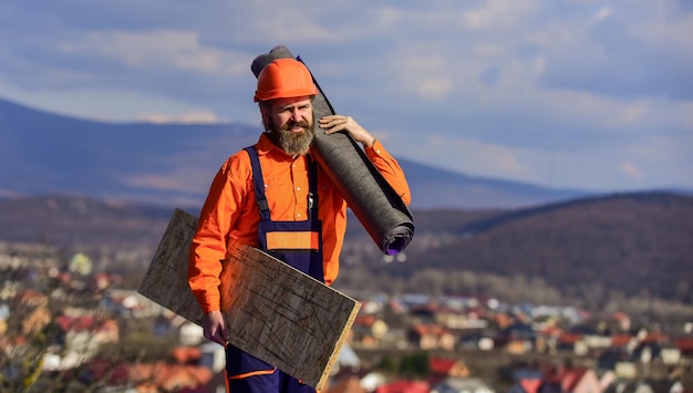 New roof under construction residential building. builder use roofing felt. professional master repair roof. Flat roof installation. Roofer worker in special protective work wear.