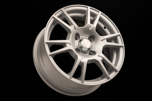 New silver alloy wheel on black background, side view,