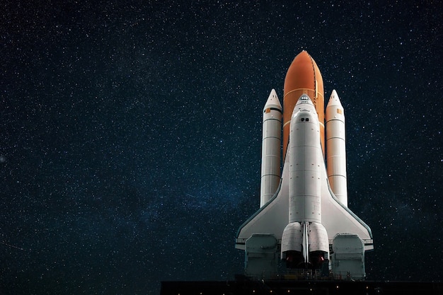 The new spacecraft shuttle prepares to take off against the backdrop of a blue starry sky. Space mission concept. Rocket flies into space