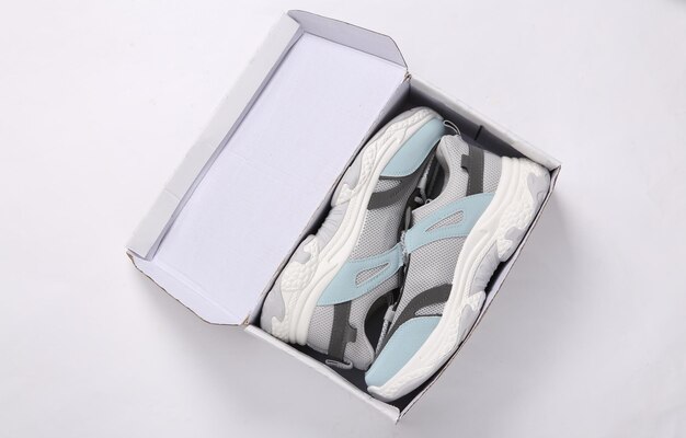 Photo new sports sneakers with box on gray background