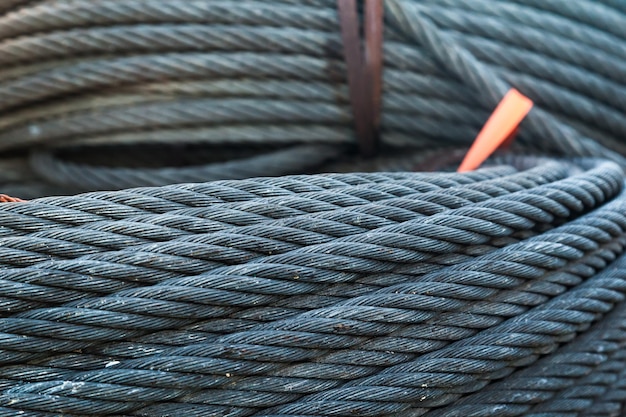 Photo new steel twisted cables twisted in a circle lie on a pile closeup