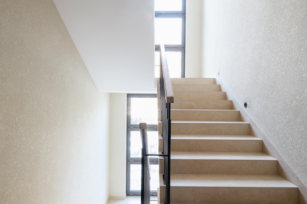 New stylish tile stairs with black metal railings in the\
house