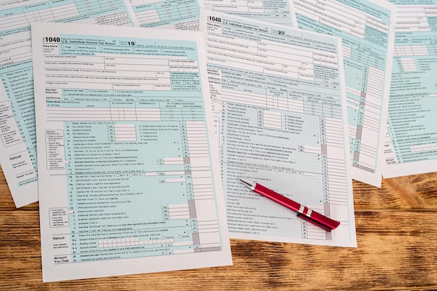 Photo new tax forms with a beautiful handle laid out to fill on a wooden table. the concept of documents