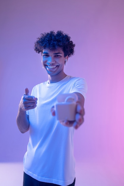 Новые технологии. Молодой афро-американский парень iholding беспроводные наушники и улыбается