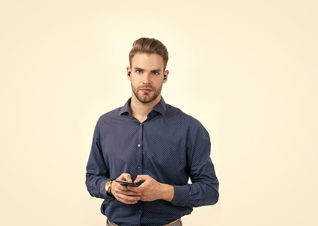 New technology unshaven guy type message online business man with wireless headphones and phone