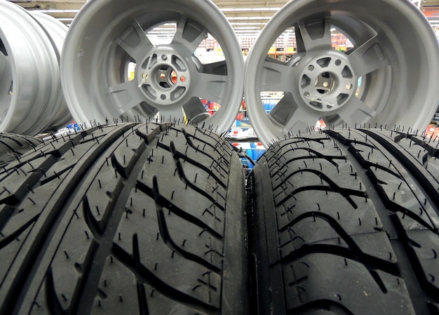 New tires and wheel rims on the shelf at car parts store stock photo