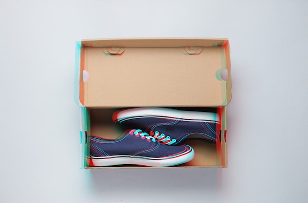 New trendy sneakers in a cardboard box on gray