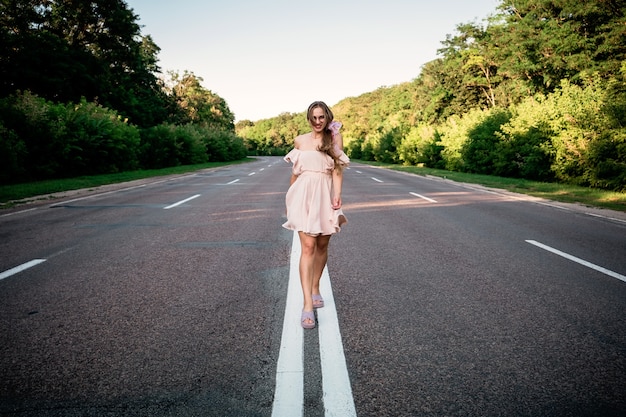 Foto nuovo modo, nuovo inizio, risoluzione del nuovo anno, sfida, scelta o concetto di cambiamento. giovane donna che cammina sulla strada estiva con albero intorno.