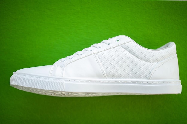 New white sneakers on a green background