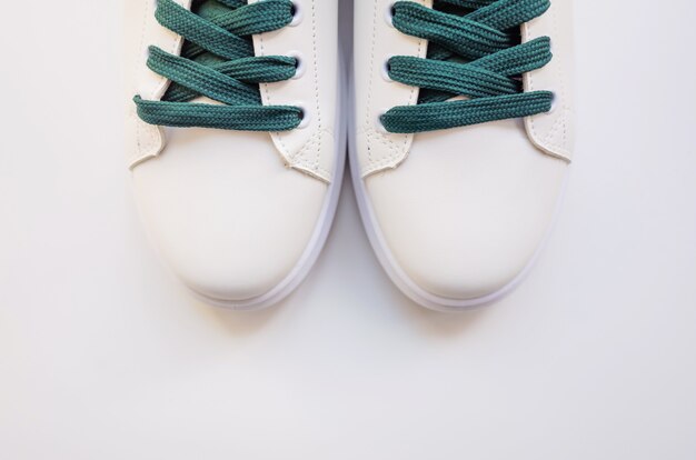 Новые белые кроссовки с зелеными шнурками