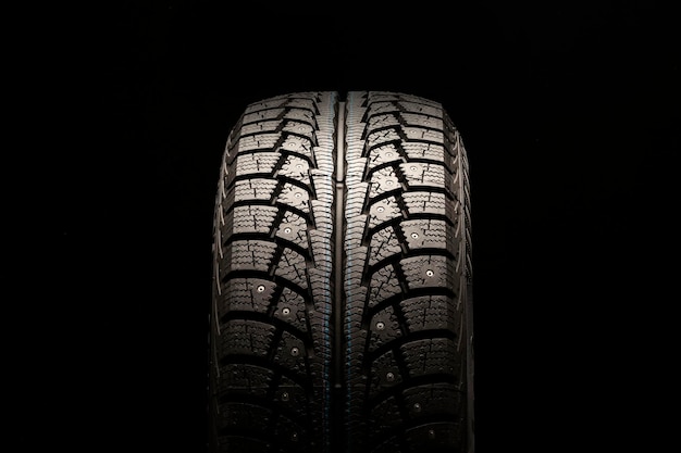 New winter studded tire on a black background