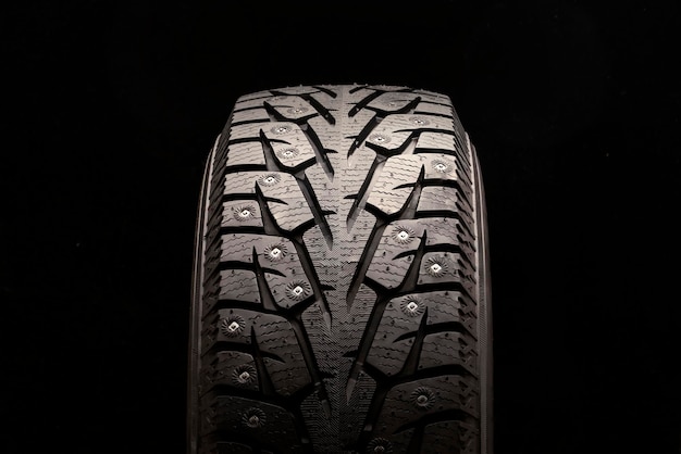 New winter studded tire on a black background