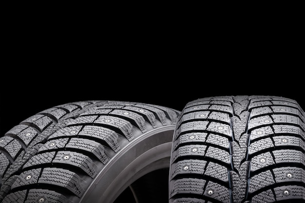 New winter studded tires, isolated on black background