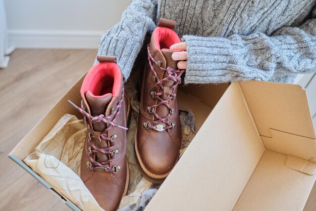Новые женские кожаные коричневые непромокаемые походные зимние осенние ботинки в женские руки, модная обувь на зиму. Распаковка обуви, покупка в Интернете из дома, магазин модной обуви