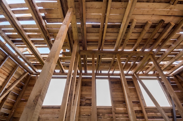 Nuova casa in legno in costruzione. close-up di pareti e telaio del soffitto con aperture per finestre dall'interno. casa da sogno ecologica di materiali naturali. concetto di costruzione, costruzione e ristrutturazione.