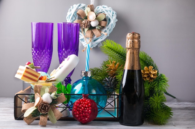 Capodannoregalo di festa di capodanno bottiglia di champagne albero verde e dolcetti