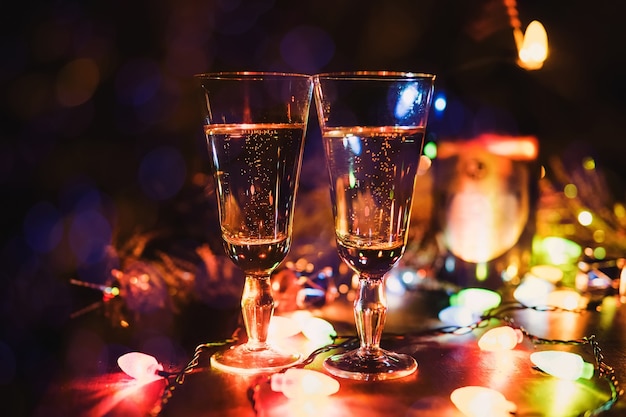 New Year 2018. The glasses of champagne. Sparklers. Christmas. Background Bokeh Lights garland