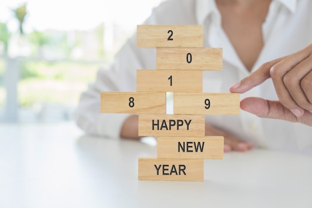 New Year 2019 concept. Young woman building 2019 concept with wooden blocks.