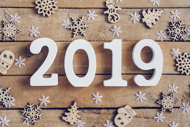 New Year 2019 on wooden brown christmas background with snowflakes 