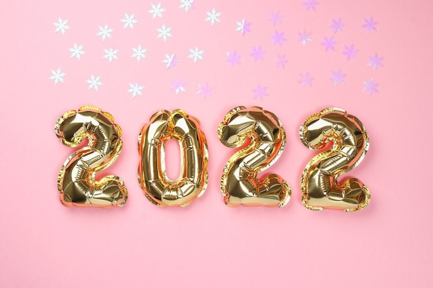 New Year 2022. Foil balloons numbers 2022 on pink background.