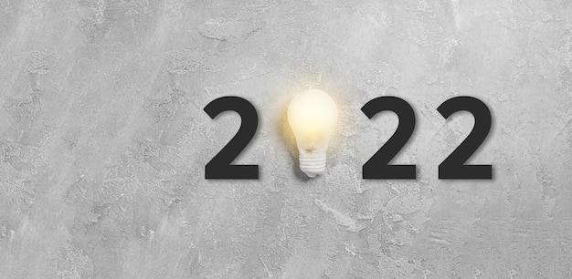 Новый год 2022 идея одна подвесная лампочка на сером бетонном фоне. Успешная бизнес-идея и творческая концепция инноваций. Плоская планировка, вид сверху, копия пространства