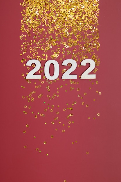 Photo new year 2022 numbers on red background with golden stars