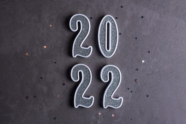 Photo new year 2022, silver numbers 2022 stand in a column on a gray concrete background, close-up.