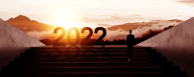 成功のシルエットに歩いているビジネスマンと2022年の新年