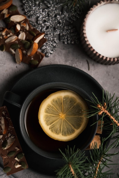 new year atmosphere, tea with lemon, chocolate and spruce branches, top view