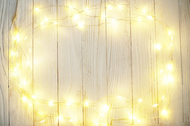 Photo new year background of bright garlands on a wooden