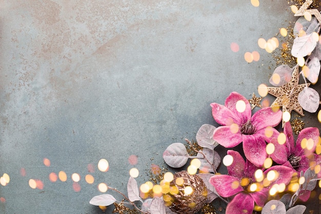 Celebrazione del nuovo anno e sfondo natalizio con fiori dorati, neve, stelle e decorazioni natalizie vista dall'alto.