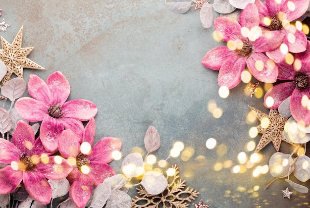 New Year celebration and Christmas background with pink flowers, snow, stars and Christmas decorations top view.