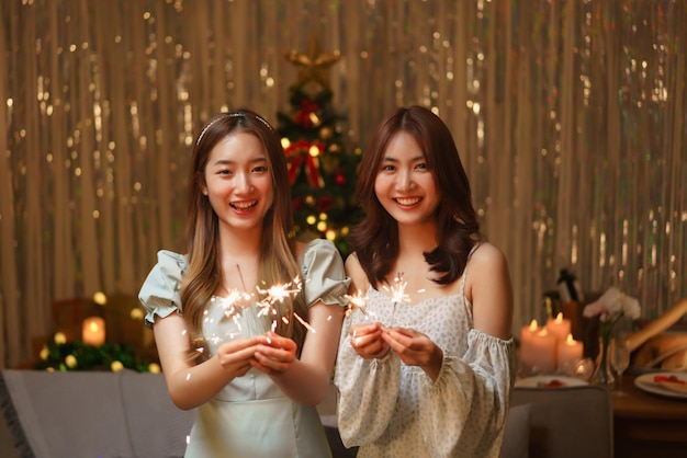 New Year celebration concept Two beautiful women holds firework sparklers to celebrating in party